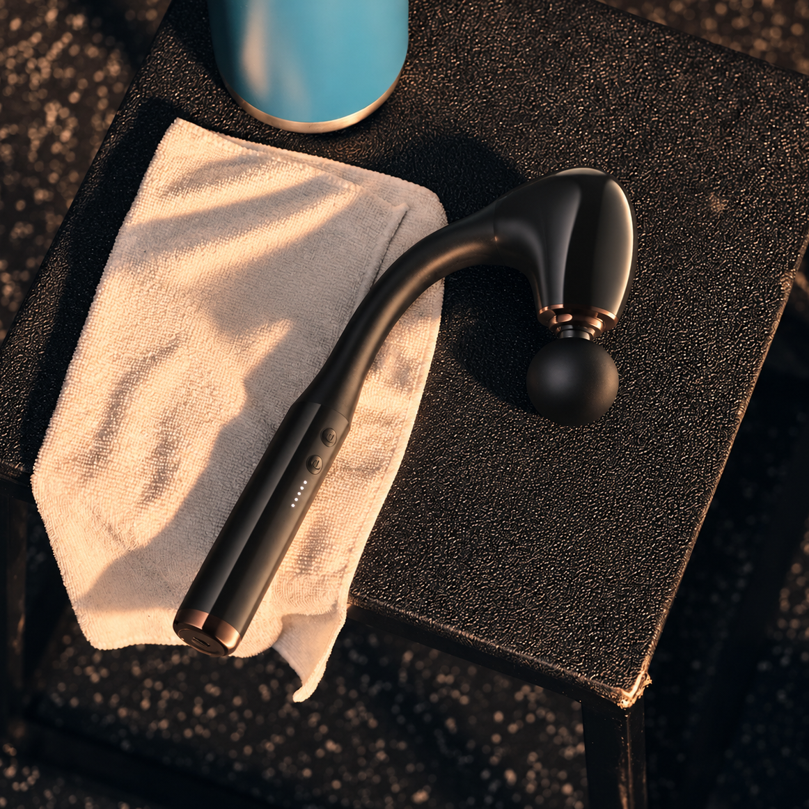 Kalos massage gun resting on a gym bench